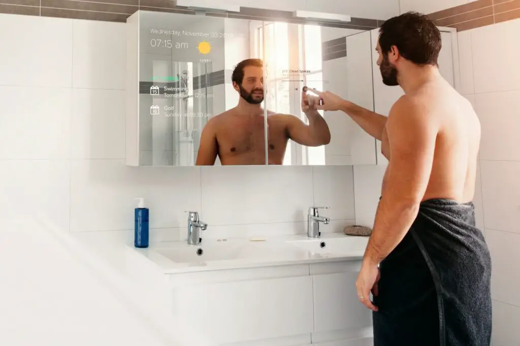 Man in his bathroom selecting a music on his smart mirror