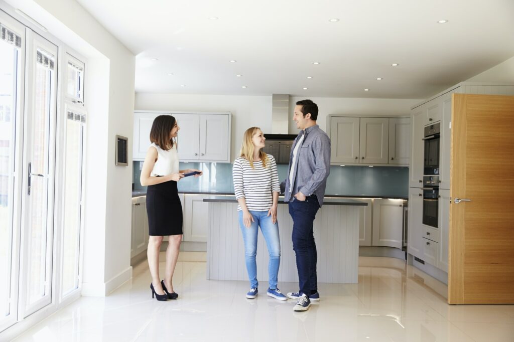 Realtor Showing Young Couple Around Property For Sale