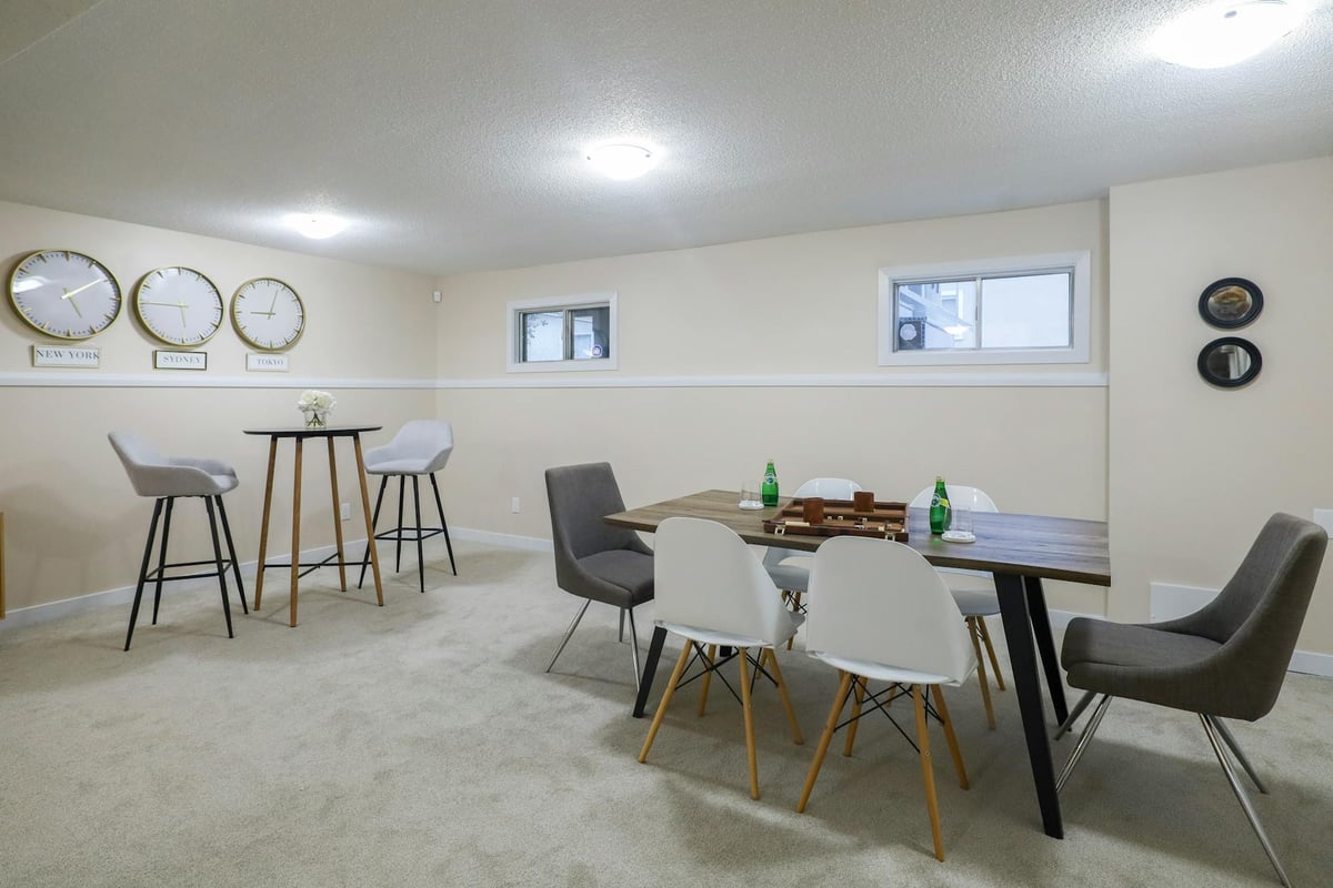 Stylish and elegant basement dining and living area with minimalist decor in Edmonton, Canada.