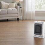 A portable electric space heater on a bare hardwood floor with clear space around it.